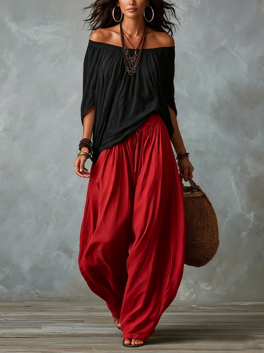 Top noir épaules dénudées et pantalon rouge ample coupe ballon